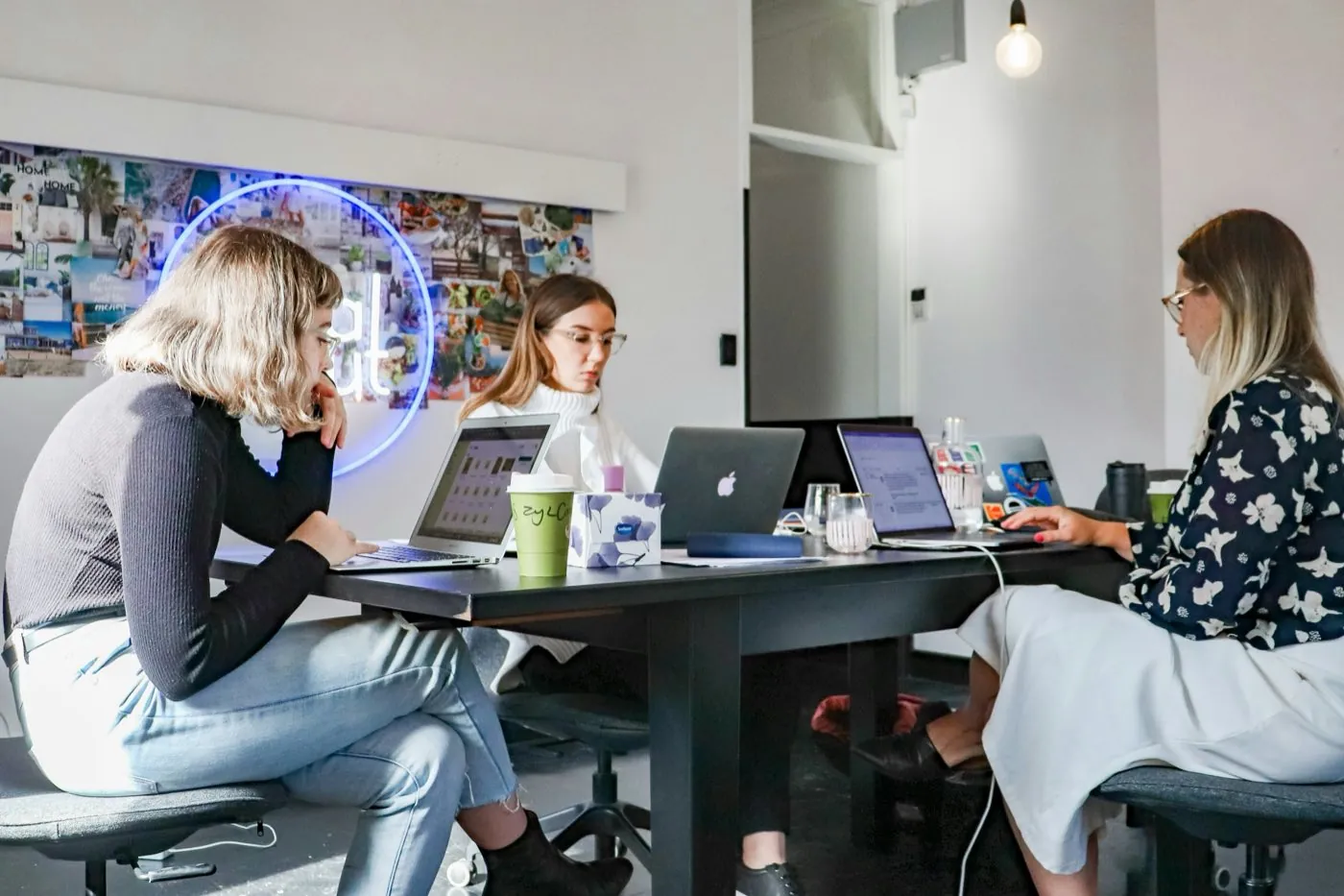 A small startup team working on laptops around a shared table